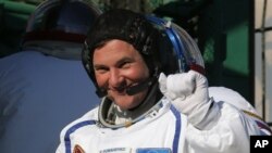 Kosmonot Roman Romanenko, salah satu kru dalam peluncuran Soyuz memberikan salamnya sebelum peluncuran roket itu, Rabu (19/12).