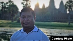 រូបឯកសារ៖ លោក ឡៅ វណ្ណា ឈរថតនៅខាងមុខប្រាសាទអង្គរវត្ត ខេត្តសៀមរាប កាលពីឆ្នាំ ២០២០។ (រូបថតផ្ដល់ឲ្យដោយក្រុមគ្រួសារ) 