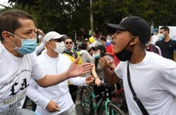 A man (L) against the national strike faces a man who supports it, during a demonstration in opposition to road blockades and violence, after a month of national protests, in Bogota, on May 30, 2021.