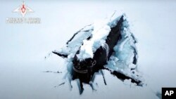 Kapal selam bertenaga nuklir Rusia muncul dari bawah lapisan es di kutub utara, dalam latihan militer Jumat (26/3). 