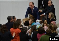 Ruling AK Party and opposition lawmakers scuffle after the independent lawmaker Aylin Nazliaka (not pictured) handcuffed herself to the rostrum during a debate to protest against the proposed constitutional changes at the Turkish Parliament in Ankara, Turkey.