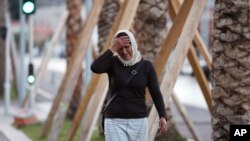 A woman cries asking for her son as she walk near the scene of an attack after a truck drove onto the sidewalk and plowed through a crowd of revelers who'd gathered to watch the fireworks in the French resort city of Nice, southern France, Friday, July 15