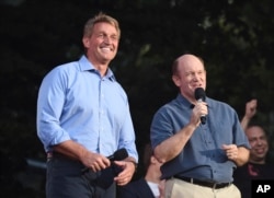 Sen. Jeff Flake, R-Ariz., left, and Sen. Chris Coons, D-Del., address the crowd at the 2018 Global Citizen Festival in Central Park, Sept. 29, 2018, in New York.