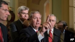 格雷厄姆-卡西迪法案的起草人格雷厄姆参议员发表讲话，他身后有卡西迪参议员和参议院多数党领袖、肯塔基州参议员米奇·麦康奈尔（2017年9月26日）