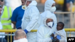 A migrant child get assistance upon arriving aboard "Lifeline", a vessel for the German charity Mission Lifeline, in the harbour of Valletta, Malta.