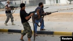 Militia fighters are seen shooting at a building in the center of Bani Walid, Libya, October 24, 2012.