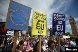 FILE - Protesters hold banners in Parliament Square during a 'March for Europe' demonstration against Britain's decision to leave the European Union, central London, Britain, July 2, 2016.