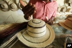 In this Dec. 16, 2017 photo, Reinaldo Quiros explains the confection of a traditional Panamanian pintao hat in La Pintada, Panama