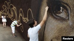 Assistants put the finishing touches on artwork project in Russia's Gorky Park, June 26, 2012.