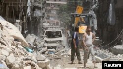 FILE - Residents inspect a damaged site after an airstrike on Aleppo's rebel held Al-Mashad neighborhood, July 26, 2016. 