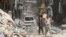 FILE - Residents inspect a damaged site after an airstrike on Aleppo's rebel held Al-Mashad neighborhood, July 26, 2016. 