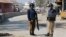 FILE - Policemen guard near the central prison where a court convicted 31 people over the campus lynching of a university student last year who was falsely accused of blasphemy, in Haripur, Pakistan, Feb. 7, 2018.
