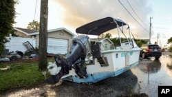 A boat rests on a street after being relocated during flooding caused by Hurricane Helene, Sept. 27, 2024, in Hudson, Florida.