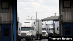 FILE - Trucks are seen after crossing the borderline from Mexico into the U.S. at the World Trade Bridge, in Laredo, Texas. 