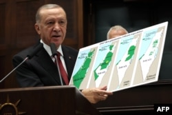 Presiden Turki dan Ketua Partai AK Recep Tayyip Erdogan memegang peta yang menunjukkan evolusi tanah Israel dan Palestina di Ankara pada 11 Oktober 2023. (Foto: AFP)