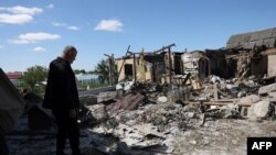 Seorang warga memeriksa sebuah rumah yang hancur akibat serangan misil Rusia ke desa Krasylivka, Kyiv, pada 8 Mei 2024. (Foto: AFP/Anatolii Stepanov)
