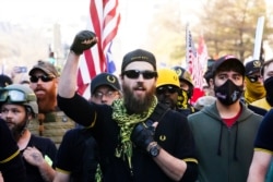 FILE - People identifying themselves as members of the Proud Boys join supporters of President Donald Trump as they march on Nov. 14, 2020, in Washington.