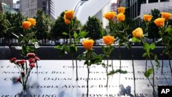 Flowers are seen placed into the groves of inscribed names of the victims of the 9/11 terrorist attacks, at the National September 11 Memorial and Museum, Sept. 11, 2020, in New York City.