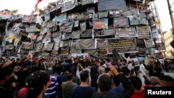 Iraqi people mourn at a makeshift shrine for victims of the Karrada suicide bomb attack at the site where the incident took place in Baghdad, Iraq, July 10, 2016. 