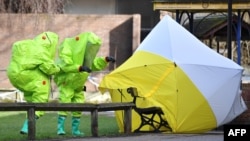 2018年3月8日，身穿防护服的英国工作人员在英国南部索尔兹伯里的斯科利帕中毒现场勘查。