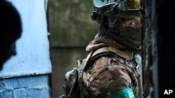 Ukrajinski vojnik gleda iz skloništa u Bakhmutu, Donjecka oblast, Ukrajina, utorak, 21. februar 2023. (AP Photo/Libkos)