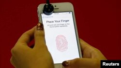A promoter demonstrates the fingerprint scanner feature of the newly launched Apple iPhone 5S in Singapore, Sept. 20, 2013. 