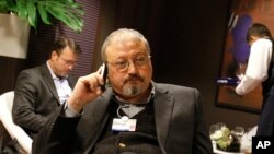 FILE - In this Jan. 29, 2011 photo, Saudi Arabian journalist Jamal Khashoggi speaks on his cellphone at the World Economic Forum in Davos, Switzerland. 