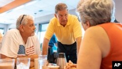 Democratic Sen. Joe Manchin, center, speaks to John Heron and Connie Hill about his recent vote in the Senate to confirm Supreme Court nominee Brett Kavanaugh, Oct. 7, 2018, at an IHOP restaurant in Charleston, W.Va. 