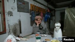A refugee sits in a shelter in the north part of Donetsk, near the airport Nov. 20, 2014.