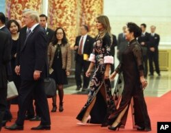 U.S. President Donald Trump, accompanied by U.S. first lady Melania Trump, second from right, and Chinese first lady Peng Liyuan, right, arrives for a state dinner at the Great Hall of the People in Beijing, Nov. 9, 2017.