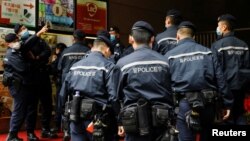 FILE - Police are seen outside the 'Stand News' office building, in Hong Kong, Dec. 29, 2021. 