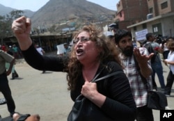Relatives protest as Peruvian authorities demolish a Shining Path mausoleum in a cemetery on the outskirts of Lima, Peru, Dec. 29, 2018. The eight Shining Path members in the mausoleum were inmates killed in a prison massacre more than 30 years ago.