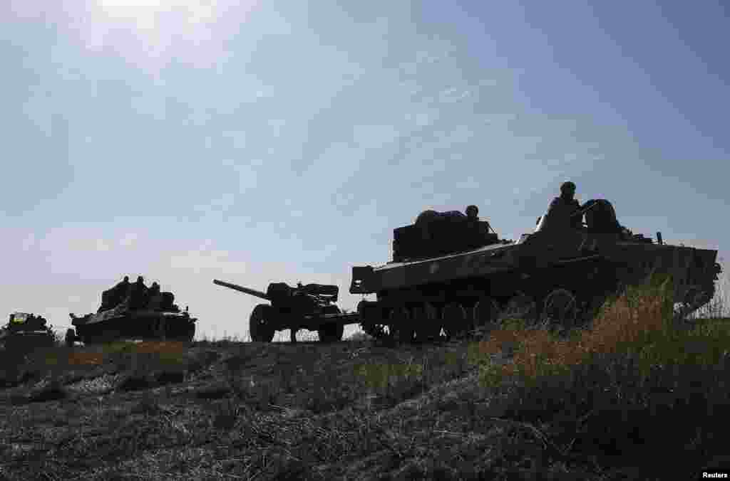A convoy from the Ukrainian armed forces, including armored personnel carriers, military vehicles and towed artillery pieces, begins to pull back from the Debaltseve region, in Blagodatne, eastern Ukraine, Feb. 27, 2015.
