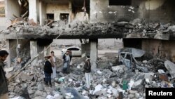 Guards stand on the rubble of a house hit by Saudi-led air strikes in Sanaa, Yemen, January 18, 2022. 