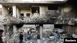 Guards stand on the rubble of a house hit by Saudi-led air strikes in Sanaa, Yemen, January 18, 2022. 