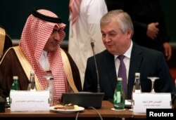 Saudi Gulf Affairs Minister Thamer Al-Sabhan, left, speaks with Russian special presidential envoy for Syria Alexander Lavrentiev during a Syrian opposition meeting in Riyadh, Saudi Arabia, Nov. 22, 2017.