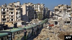 Bus-bus terlihat berderet selama operasi evakuasi pejuang pemberontak dan keluarga mereka dari lingkungan yang dikuasai pemberontak di Aleppo, 15 Desember 2016. (AFP PHOTO / KARAM AL-MASRI)