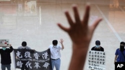 Protesters gesture with five fingers, signifying 'Five demands - not one less' in a shopping mall during a protest against China's national security legislation for the city, in Hong Kong, May 29, 2020.
