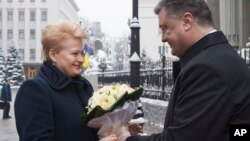 Ukrainian President Petro Poroshenko, right, greets Lithuania's President Dalia Grybauskaite in Kyiv, Nov. 24, 2014.