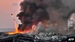 A helicopter puts out a fire at the scene of an explosion at the port of Lebanon's capital Beirut on August 4, 2020. (Photo by STR / AFP)