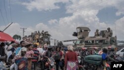 Raia wakikusanyika karibu na magari ya kivita ya wanajeshi wa Afrika Kusini wa kikosi cha SADC nchini DRC, Februari 7, 2024. Picha ya AFP
