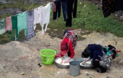 Displaced Syrian women who fled from southern Idlib wash clothes in Afrin, Syria February 7, 2020. REUTERS/Khalil Ashawi - RC2SVE9Q1Z67