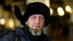 Homeless man Kaspars Breidaks from Latvia poses for a portrait during an interview with the Associated Press in guest room of Berlin's biggest restaurant Hofbraeu Berlin, in Berlin, Germany, Thursday, Dec. 17, 2020. (AP Photo/Markus Schreiber)