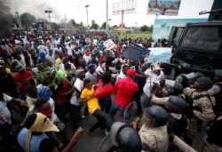 Demonstrators scuffle with the police during a protest calling for the resignation of President Jovenel Moise, near the airport in Port-au-Prince, Haiti, Oct. 4, 2019.