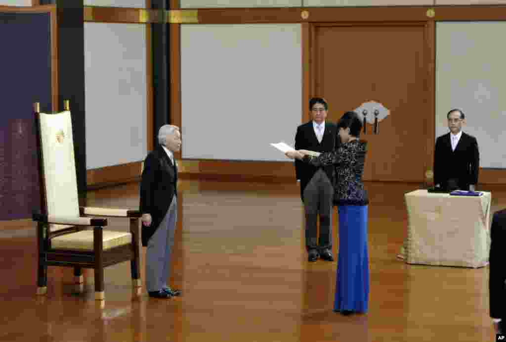 Kaisar Akihito (kiri), didampingi Perdana Menteri Jepang Shinzo Abe (kedua dari kiri) berdiri sementara Menteri Perdagangan dan Ekonomi yang baru Yuko Obuchi, menerima sertifikat pengesahan dalam upacara di Istana Imperial, Tokyo (3/9).