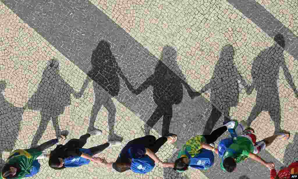 Warga Brazil berjalan di sepanjang pantai Copacabana, Rio de Janeiro pada tanggal 28 Juli 2013 usai mengikuti acara misa terakhir Paus Fransiskus di Brasil.