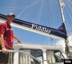 James Hilliard, anggota termuda dari generasi Hilliard yang berpartisipasi dalam "Sail Sabang Regatta" berpose dengan kapal layar Fiddler.