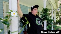 Gavin Grimm leans on a post on his front porch during an interview at his home in Gloucester, Va. Grimm is a transgender student whose demand to use the boys' restrooms has divided the community and prompted a lawsuit.