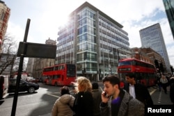 People walk past the building housing the offices of Cambridge Analytica in central London, Britain, March 20, 2018.