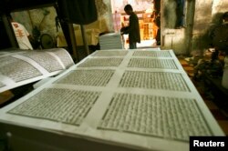 FILE - A worker looks checks printing paper for the Koran near the Sunan Ampel mosque in Surabaya, Indonesia East Java province, July 27, 2011.